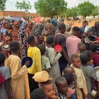Des femmes et des enfants attendent leur tour pour recevoir de la nourriture distribuée gratuitement dans le camp de déplacés d'al-Mohayra, près de la ville d'El-Obeid, dans la région du Kordofan du Sud, le 29 juin 2026. (Crédit : AFP)