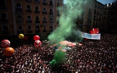 Des festivaliers réunis pour célébrer le « Chupinazo » marquant le début officiel des fêtes de San Fermín sur la Plaza Consistorial, devant la mairie de Pampelune, dans le nord de l’Espagne, le 6 juillet 2026. (Crédit : Jorge Guerrero/AFP)