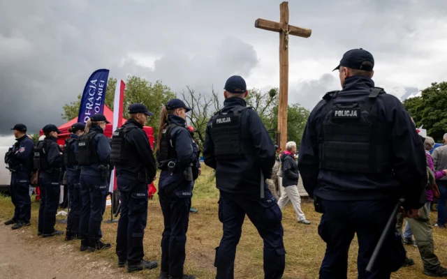 Des policiers montent la garde lors d'un rassemblement de partisans d'extrême droite devant le monument commémoratif du massacre de Jedwabne, érigé en mémoire des habitants juifs de la ville assassinés le 10 juillet 1941 par leurs voisins polonais, à Jedwabne, dans le nord-est de la Pologne, le 10 juillet 2026. (Crédit: Wojtek RADWANSKI / AFP) Des policiers montent la garde lors d'un rassemblement de partisans d'extrême droite devant le monument commémoratif du massacre de Jedwabne, érigé en mémoire des habitants juifs de la ville assassinés le 10 juillet 1941 par leurs voisins polonais, à Jedwabne, dans le nord-est de la Pologne, le 10 juillet 2026. (Crédit: Wojtek RADWANSKI / AFP)