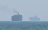 Cette image extraite d’une vidéo de l’AFPTV datée du 12 juillet 2026 montre des cargos jetant l’ancre près du détroit d’Ormuz, au large de la côte orientale des Émirats arabes unis, à Khor Fakkan (Crédit: AFPTV/AFP)