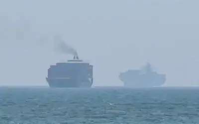 Cette image extraite d’une vidéo de l’AFPTV datée du 12 juillet 2026 montre des cargos jetant l’ancre près du détroit d’Ormuz, au large de la côte orientale des Émirats arabes unis, à Khor Fakkan (Crédit: AFPTV/AFP)