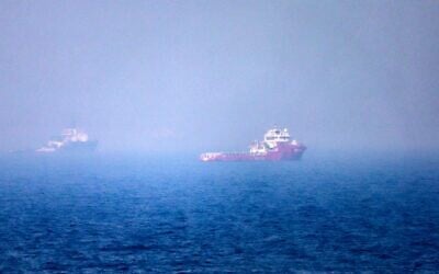 Des navires naviguant près du détroit d'Ormuz, au large de la côte orientale des Émirats arabes unis, à Khor Fakkan, le 13 juillet 2026. (Crédit : AFP)