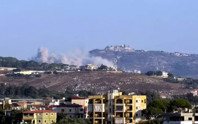 Cette photographie prise depuis la ville de Nabatieh, dans le sud du Liban, montre la fumée s'élevant du lieu d'une explosion provoquée par Israël dans le village de Kfar Tibnit, avec la citadelle de Beaufort visible au loin, le 13 juillet 2026 (Crédit: Abbas FAKIH/AFP)