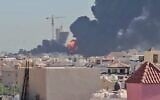 Un panache de fumée noire et des flammes s'élevant au-dessus de la ville de Mangaf, au sud de Koweït City, capture d'écran tirée d'une vidéo amateur publiée sur les réseaux sociaux le 18 juillet 2026. (Crédit : Sources diverses/AFP)