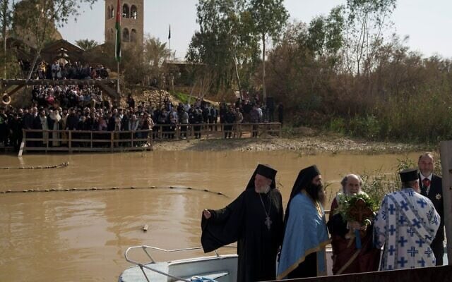 Le patriarche orthodoxe grec de Jérusalem, Théophile III (au centre), se tenant debout dans une barque lors d’une cérémonie sur les eaux du Jourdain, dans le cadre d’une cérémonie de baptême organisée à l’occasion de la fête orthodoxe de l’Épiphanie sur le site baptismal de Qasr al-Yahud, près de Jéricho, en Cisjordanie, en Israël, le 18 janvier 2024 (Crédit : Leo Correa/AP) Le patriarche orthodoxe grec de Jérusalem, Théophile III (au centre), se tenant debout dans une barque lors d’une cérémonie sur les eaux du Jourdain, dans le cadre d’une cérémonie de baptême organisée à l’occasion de la fête orthodoxe de l’Épiphanie sur le site baptismal de Qasr al-Yahud, près de Jéricho, en Cisjordanie, en Israël, le 18 janvier 2024 (Crédit : Leo Correa/AP)