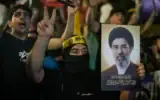 Un partisan du Hezbollah fait le signe de la victoire tout en brandissant une affiche du Guide suprême iranien Mojtaba Khamenei lors d’un rassemblement contre l’opération militaire américano-israélienne visant l’Iran et ses alliés à Dahiyeh, au Liban, mercredi 10 juin 2026. (Crédit: AP/Bilal Hussein)