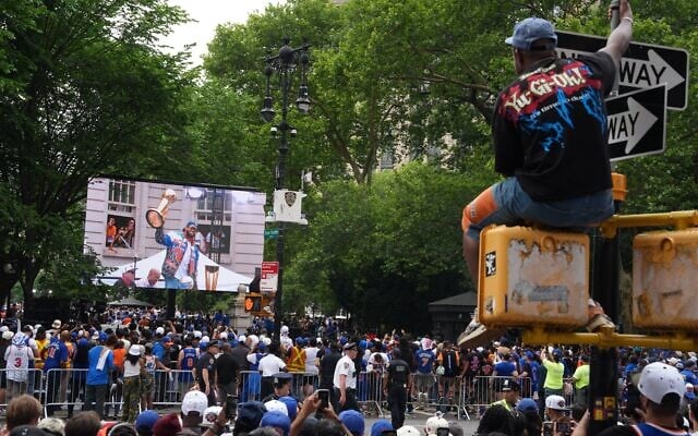 Des fans assistent au défilé célébrant le titre de champion NBA des Knicks de New York, le jeudi 18 juin 2026 à New York. (Crédit : AP/Ryan Murphy)
