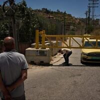 Un Palestinien franchissant un barrage routier érigé par l'armée israélienne aux entrées du village de Sinjil, en Cisjordanie, le 1ᵉʳ juillet 2026. (Crédit : Leo Correa/AP)