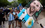 Un supporter brandit une banderole géante à l'effigie de Lionel Messi alors que les supporters argentins se rassemblent pour célébrer et manifester leur soutien à leur équipe dans un parc en bord de mer à Miami Beach, en Floride, le 2 juillet 2026. (Crédit:  AP/Rebecca Blackwell)