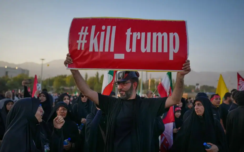 Un homme tient une pancarte sur laquelle on peut lire "#kill_trump"  alors que des personnes en deuil se rassemblent pour les funérailles du Guide suprême iranien, l'ayatollah Ali Khamenei, assassiné, à Téhéran, en Iran, le 5 juillet 2026. (Crédit : AP/Altaf Qadri)