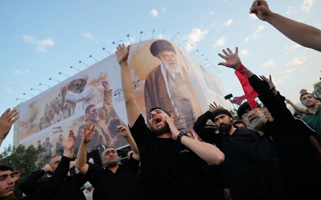 Des personnes en deuil scandent des slogans, rassemblées sur la place de la Révolution islamique à Téhéran, en Iran, le 6 juillet 2026, à l'occasion des funérailles du guide suprême iranien assassiné, l'ayatollah Ali Khamenei, sous un panneau d'affichage à son effigie. (Crédit : AP/Altaf Qadri)
