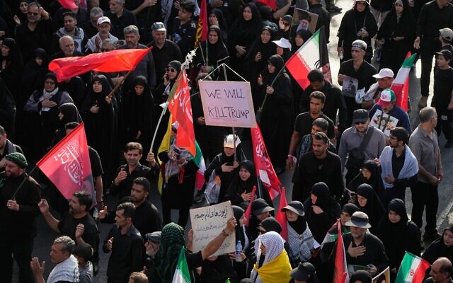 Un participant au cortège funèbre portant une pancarte sur laquelle on peut lire « Nous tuerons Trump » alors que la foule se dirige vers le cortège funèbre du guide suprême iranien Ali Khamenei, à Téhéran, en Iran, le 6 juillet 2026. (Crédit : Vahid Salemi/AP)
