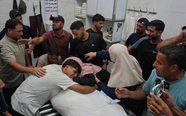 Des amis et des proches pleurant la mort d'Omran Abu Jarad, 48 ans, tué lors d'une frappe militaire israélienne, lors de ses funérailles à l'hôpital Shifa de Gaza-City, le 7 juillet 2026. (Crédit : Abdel Kareem Hana/AP)