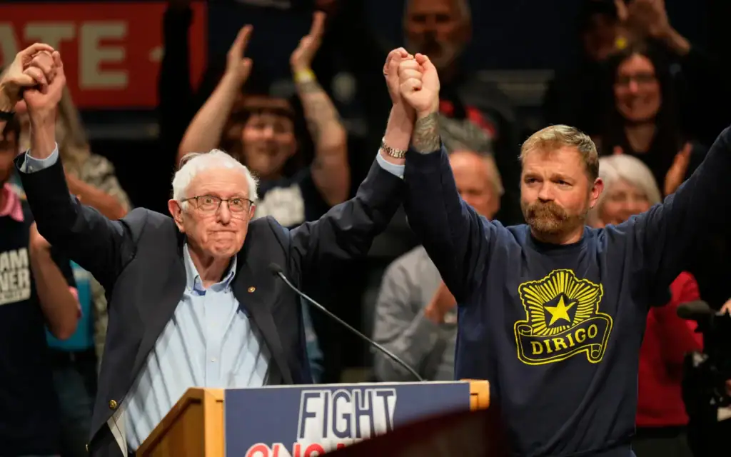 Graham Platner, candidat démocrate au Sénat américain, et le sénateur Bernie Sanders (indépendant du Vermont), à gauche, se tiennent la main lors d'un événement à Orono, dans le Maine, le 24 mai 2026. (Crédit: AP/Robert F. Bukaty, archives)