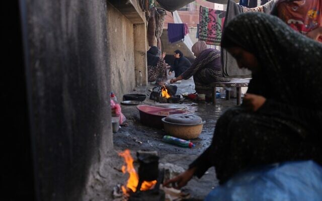 Mariam Sahmoud, 43 ans (au centre), préparant un repas sur le toit de la mosquée Bilal, transformée en centre d'accueil pour des Gazaouis déplacés à Khan Younès, dans le sud de la bande de Gaza, le 10 juillet 2026. (Crédit : Abdel Kareem Hana/AP)