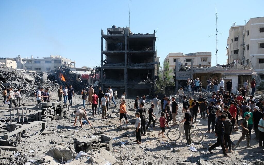 Des Palestiniens se rassemblent près du site d'une frappe de drone israélien dans le quartier de Sabra, à Gaza-City, le 12 juillet 2026. (Crédit : AP Photo/Jehad Alshrafi)