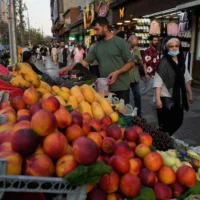 Un vendeur de fruits disposant ses marchandises sur son étal sur la place Tajrish, au nord de Téhéran, en Iran, le 13 juillet 2026. (Crédit : Vahid Salemi/AP)