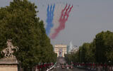 Des avions de la Patrouille de France survolent le défilé militaire du 14 juillet sur l'avenue des Champs-Élysées à Paris, le mardi 14 juillet 2026. (Crédit :  AP/Thomas Padilla)