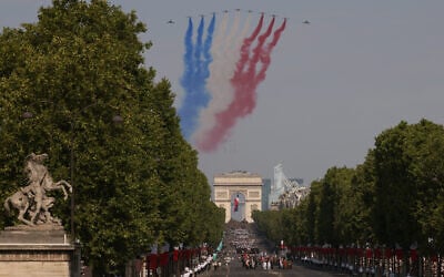 Des avions de la Patrouille de France survolent le défilé militaire du 14 juillet sur l'avenue des Champs-Élysées à Paris, le mardi 14 juillet 2026. (Crédit :  AP/Thomas Padilla)