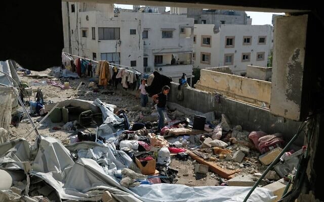 Des habitants inspectant le site d'une frappe aérienne israélienne, à Gaza-City, le 18 juillet 2026. (Crédit : Jehad Alshrafi/AP) Des habitants inspectant le site d'une frappe aérienne israélienne, à Gaza-City, le 18 juillet 2026. (Crédit : Jehad Alshrafi/AP)