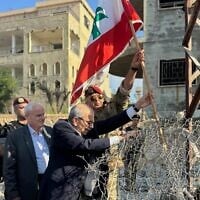 Le Premier ministre libanais Nawaf Salam (au centre) hissant le drapeau libanais lors d’une visite dans le village de Zawtar Al Gharbieh, dans le sud du Liban, le 22 juillet 2026. (Crédit : Service de presse du gouvernement libanais via AP)