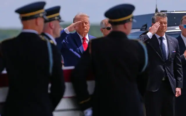 Le président américain Donald Trump et le secrétaire américain à la Défense, Pete Hegseth, effecuant le salut militaire tandis qu’une équipe de transport de l’armée américaine déplace un cercueil contenant la dépouille du sergent Angel S. Rampersad, originaire d’Ozone Park, dans l’État de New York, à la base aérienne de Dover, dans le Delaware, le 22 juillet 2026. (Crédit : Matt Rourke/AP)