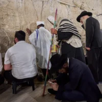 Des hommes juifs ultra-orthodoxes prient pendant le jeûne de Tisha BeAv au mur Occidental, dans la Vieille Ville de Jérusalem, le 22 juillet 2026. (Crédit : Ohad Zwigenberg/AP)