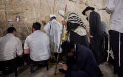 Des hommes juifs ultra-orthodoxes prient pendant le jeûne de Tisha BeAv au mur Occidental, dans la Vieille Ville de Jérusalem, le 22 juillet 2026. (Crédit : Ohad Zwigenberg/AP)