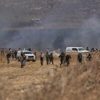 Des résidents d'implantations extrémistes incendiant des terres agricoles près de la ville de Beit Furik, en Cisjordanie, le 13 juillet 2026. (Crédit : Majdi Mohammed/AP)
