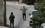 Un soldat israélien interrogeant un habitant palestinien lors d’une opération militaire dans le village de Tell, en Cisjordanie, près de Naplouse, le 25 juillet 2026. (Crédit : Majdi Mohammed/AP)