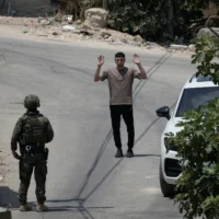 Un soldat israélien interrogeant un habitant palestinien lors d’une opération militaire dans le village de Tell, en Cisjordanie, près de Naplouse, le 25 juillet 2026. (Crédit : Majdi Mohammed/AP)