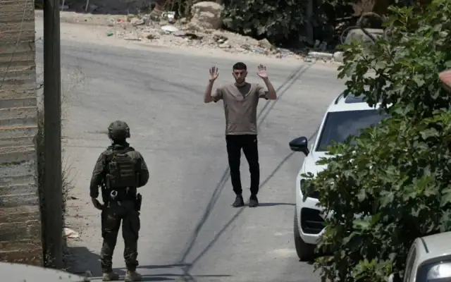 Un soldat israélien interrogeant un habitant palestinien lors d’une opération militaire dans le village de Tell, en Cisjordanie, près de Naplouse, le 25 juillet 2026. (Crédit : Majdi Mohammed/AP)