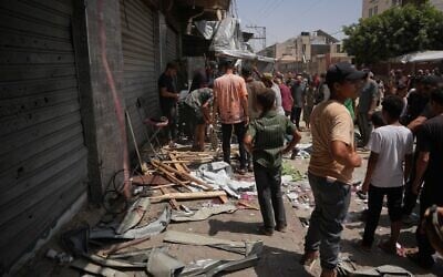 Des Palestiniens inspectent le site d'une frappe militaire israélienne à Deir al-Balah, dans le centre de la bande de Gaza, le 25 juillet 2026. (Crédit : AP Photo/Abdel Kareem Hana)