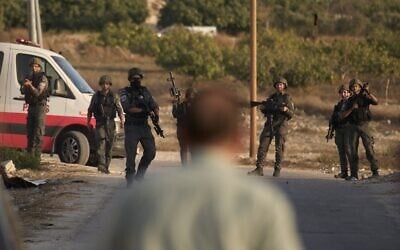 Des membres des forces de sécurité israéliennes montant la garde lors d'une opération menée dans le village de Sarra, près de la ville de Naplouse, en Cisjordanie, le 25 juillet 2026. (Crédit : Leo Correa/AP) Des membres des forces de sécurité israéliennes montant la garde lors d'une opération menée dans le village de Sarra, près de la ville de Naplouse, en Cisjordanie, le 25 juillet 2026. (Crédit : Leo Correa/AP)