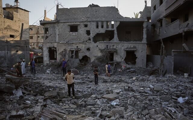 Des Gazaouis inspectant les décombres d’un bâtiment détruit lors d’une frappe aérienne israélienne à Deir al-Balah, au centre de la bande de Gaza, le 29 juillet 2026. (Crédit : Abdel Kareem Hana/AP)