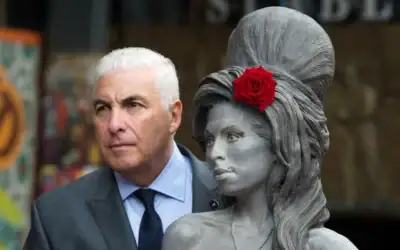 Mitch Winehouse pose pour une photo avec une statue de sa défunte fille, Amy Winehouse, après son inauguration au Stables Market de Camden, à Londres, le 14 septembre 2014. (Crédit : AP/Tim Ireland/Archives)
