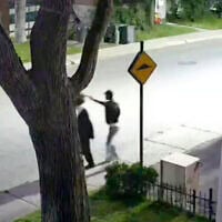 Capture d’écran d’une vidéo montrant un individu s’approcher d’une personne juive hassidique et lui voler son chapeau. (Crédit : CJHQ / Facebook)