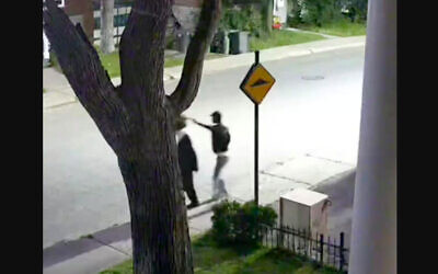 Capture d’écran d’une vidéo montrant un individu s’approcher d’une personne juive hassidique et lui voler son chapeau. (Crédit : CJHQ / Facebook)