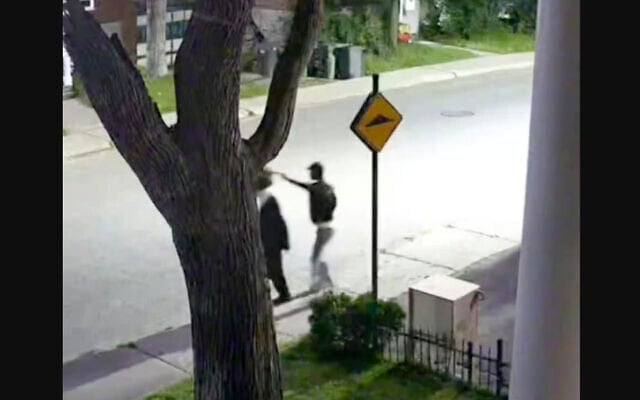 Capture d’écran d’une vidéo montrant un individu s’approcher d’une personne juive hassidique et lui voler son chapeau. (Crédit : CJHQ / Facebook)