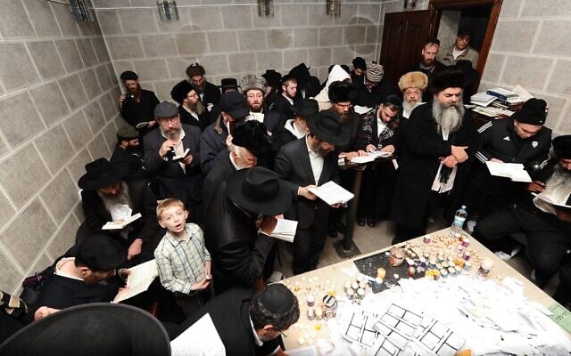 Des juifs orthodoxes du mouvement hassidique Habad prient sur la tombe du fondateur du mouvement, le rabbin Shneur Zalman, à Hadiach, en Ukraine. 27 décembre 2013. (Crédit : Mendy Hechtman/FLASH90)