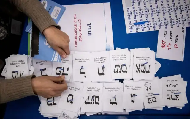 Des employés de la Commission centrale des élections faisant le décompte des bulletins de vote au Parlement israélien, à Jérusalem, après les élections législatives, le 25 mars 2020. (Crédit : Yonatan Sindel/Flash90)