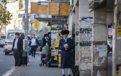 Des passants dans une rue de la ville ultra-orthodoxe de Bnei Brak, dans le centre d'Israël, le 2 mars 2026. (Crédit : Chaïm Goldberg/Flash90)
