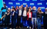 Les députés Naama Lazimi (veste rouge) et Gilad Kariv (à sa droite) célèbrent leur victoire avec d'autres responsables du parti Les Démocrates après avoir décroché respectivement les deuxième et troisième places sur la liste du parti pour la Knesset, derrière le chef du parti Yair Golan (à la droite de Kariv). Les candidats se sont réunis à Tel Aviv le 20 juillet 2026, à l'issue des primaires du parti. (Crédit : Avshalom Sassoni/Flash90)