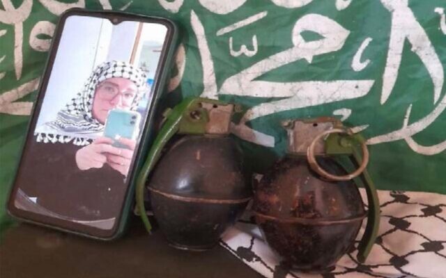Une photo non datée de Catherine Washburn au téléphone, devant un drapeau du groupe terroriste palestinien du Hamas et deux grenades. (Crédit : Tribunal du district ouest de New York) Une photo non datée de Catherine Washburn au téléphone, devant un drapeau du groupe terroriste palestinien du Hamas et deux grenades. (Crédit : Tribunal du district ouest de New York)