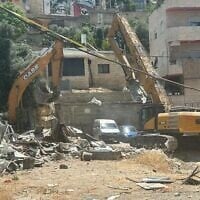Un bulldozer démolissant une maison dans le quartier d'al-Bustan, à Jérusalem-Est, le 25 mai 2026. (Crédit : Communauté d'al-Bustan)
