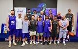 Les anciens otages David et Ariel Cunio, Bar Kupershtein, Elkana Bohbot, Eliya Cohen, Or Levy et Eitan Horn se joignent à des représentants de la Diaspora pour un match amical de basket-ball lors des Maccabiades, le 8 juillet 2026. (Crédit : Maccabiades/Gilad Kavalerchik)