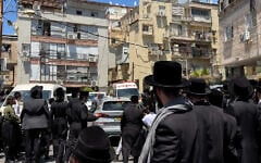 Des haredim lancent des pierres et d'autres projectiles sur un véhicule dans lequel se trouvent des agents de l'administration fiscale israélienne, que la police tente d'évacuer en sécurité à Bnei Brak, le 17 juillet 2026.. (Crédit : Capture d'écran/X)