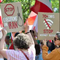 Des manifestants brandissant des pancartes se rassemblent près du pont Francis Scott Key lors d'un rassemblement organisé en soutien au peuple iranien et pour condamner l'exécution de prisonniers politiques en Iran, à Washington, DC, le 16 mai 2026. (Crédit: Amid Farahi/AFP)