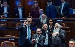 Le chef du parti Shas, Aryeh Deri (faisant un geste, au centre gauche), et d’autres députés ultra-orthodoxes à la Knesset lors d’un vote sur une loi gelant les arrestations des réfractaires ultra-orthodoxes, le 14 juillet 2026. (Crédit : Chaïm Goldberg/Flash90)