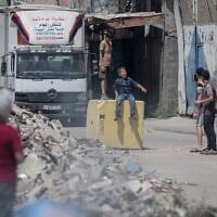 Des enfants gazaouis jouant sur un bloc de béton destiné à marquer la « Ligne jaune » établie par Israël, dans le quartier de Shejaiya, à l'est de Gaza-City, le 26 juillet 2026. (Crédit : Mohammed M. Skaik/JNA Press/Sipa USA via Reuters)
